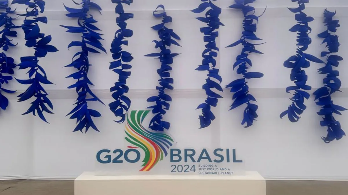 Diversas tiras de Côco azul penduradas em cachos na atrás do totem do G20 Brasil Rio Summit 2024, na entrada da Sala de Imprensa.